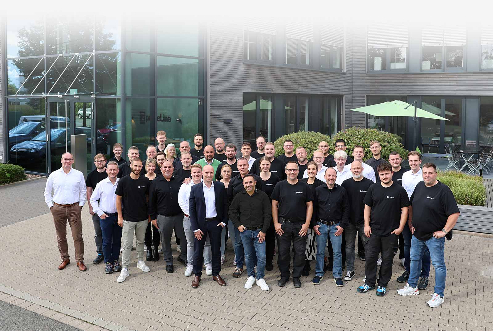Gruppenfoto des primeLine Solutions Teams in Bad Oeynhausen vor dem HQ